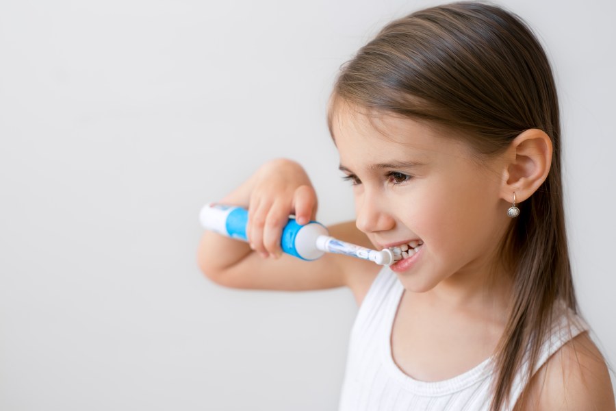 dete pere zube elektricnom cetkicom - devojcica koristi elektricnu cetkicu za zube
