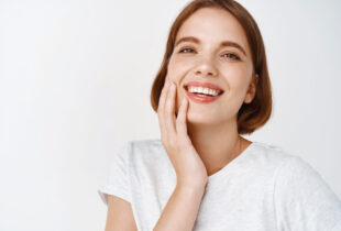 https://hollywoodsmile.rs/wp-content/uploads/2022/11/beauty-close-up-happy-woman-with-short-hair-touching-clean-fresh-facial-skin-smiling-showing-perfect-teeth-face-standing-against-white-wall.jpg